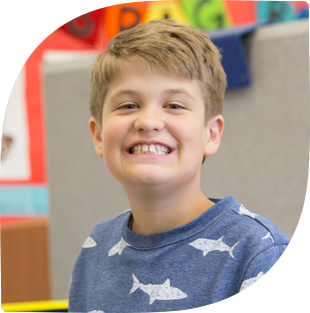 Young boy smiling in classroom