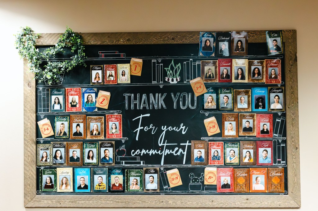 NewHope Academy staff recognition display featuring framed portraits and a thank you message