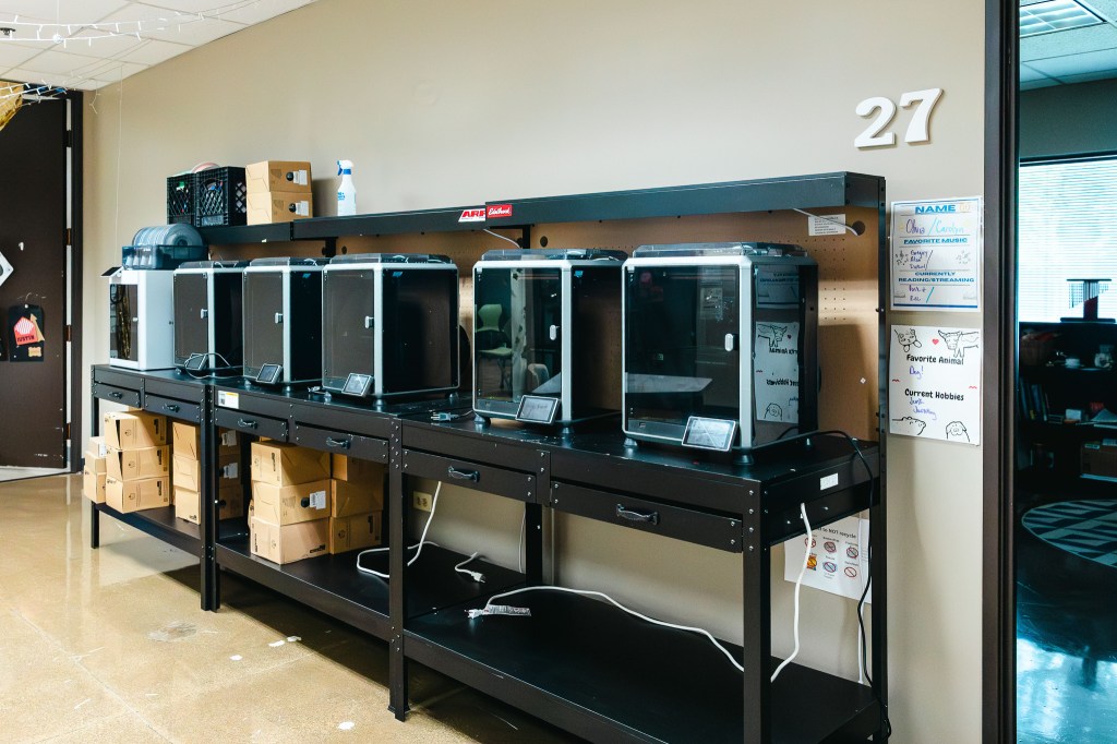 Row of 3D printers in a NewHope Academy makerspace and student learning area