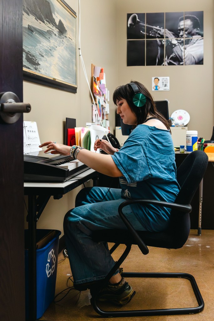 NewHope Academy student playing an electronic keyboard while wearing headphones