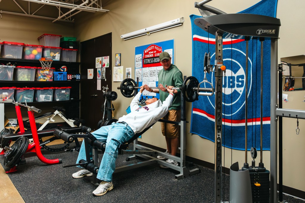 NewHope Academy student using weight training equipment with staff supervision