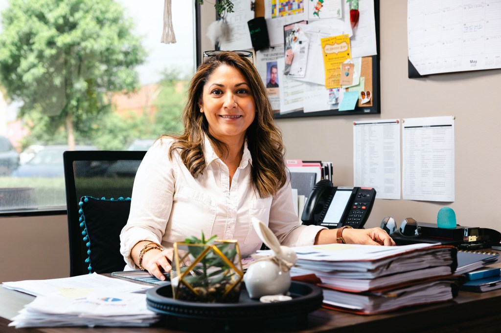 NewHope Academy staff member seated at her desk in a school office