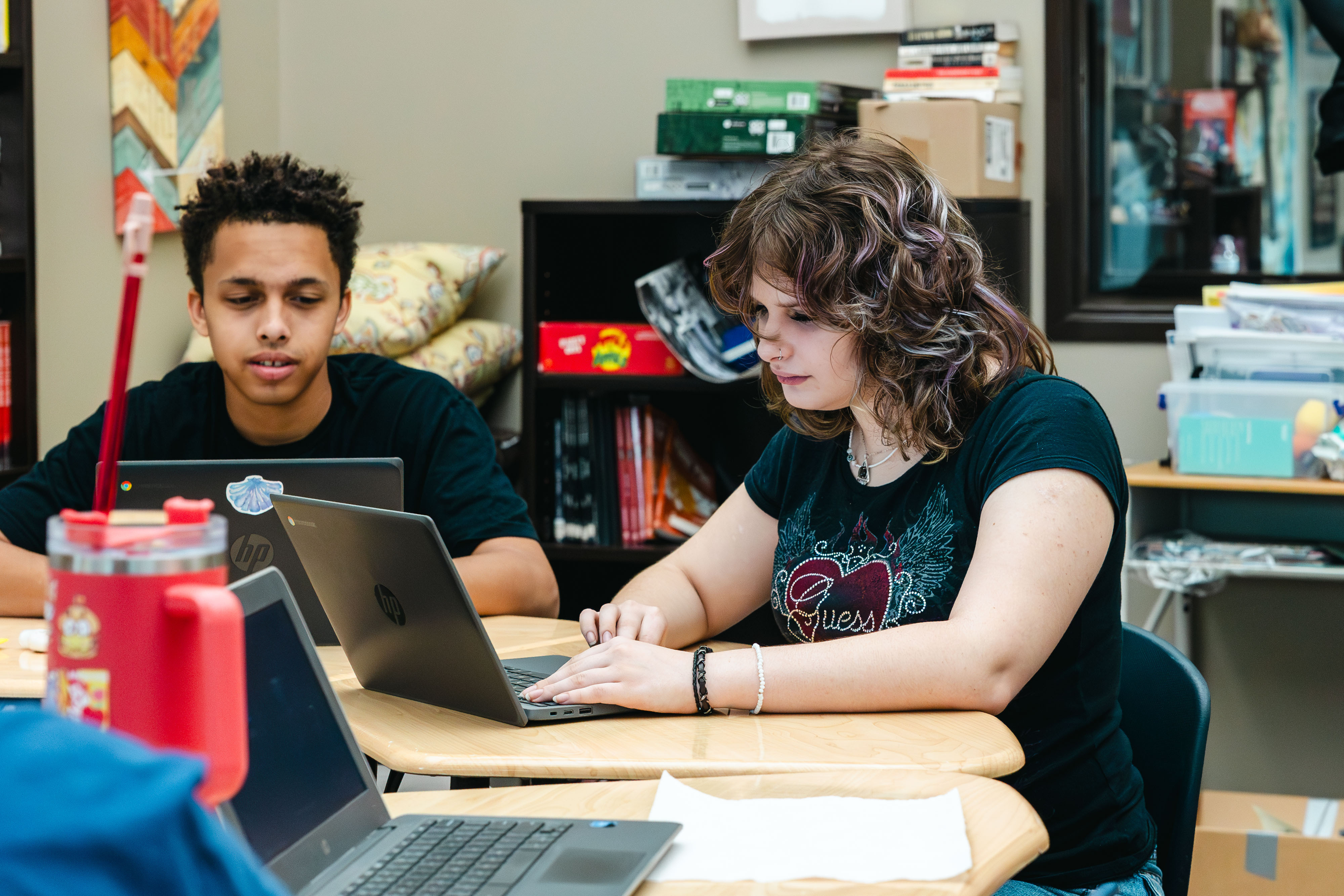 NewHope Academy students work on laptops together during classroom learning activities.