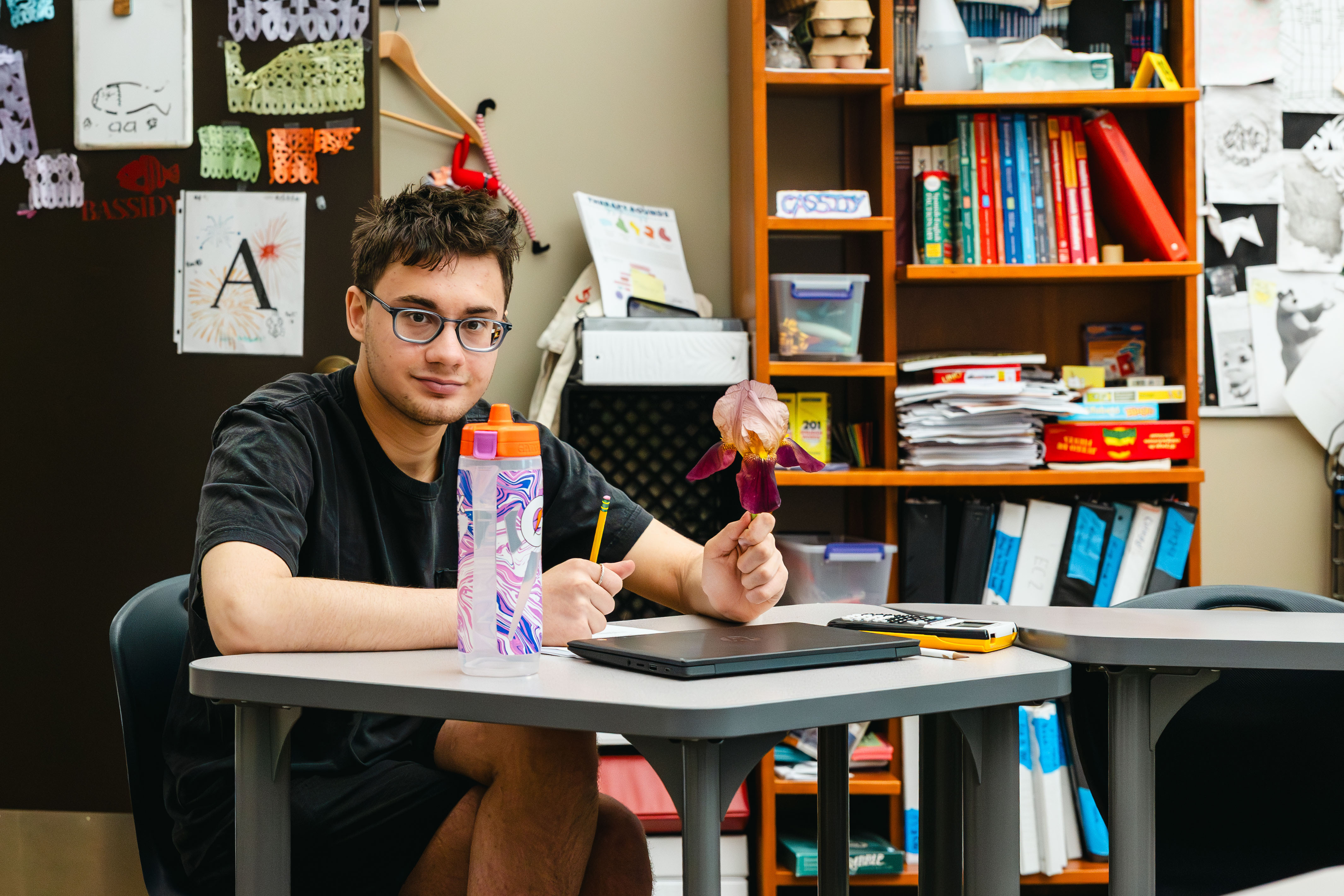 NewHope Academy student works at a classroom desk with a laptop, pencil, and learning materials.