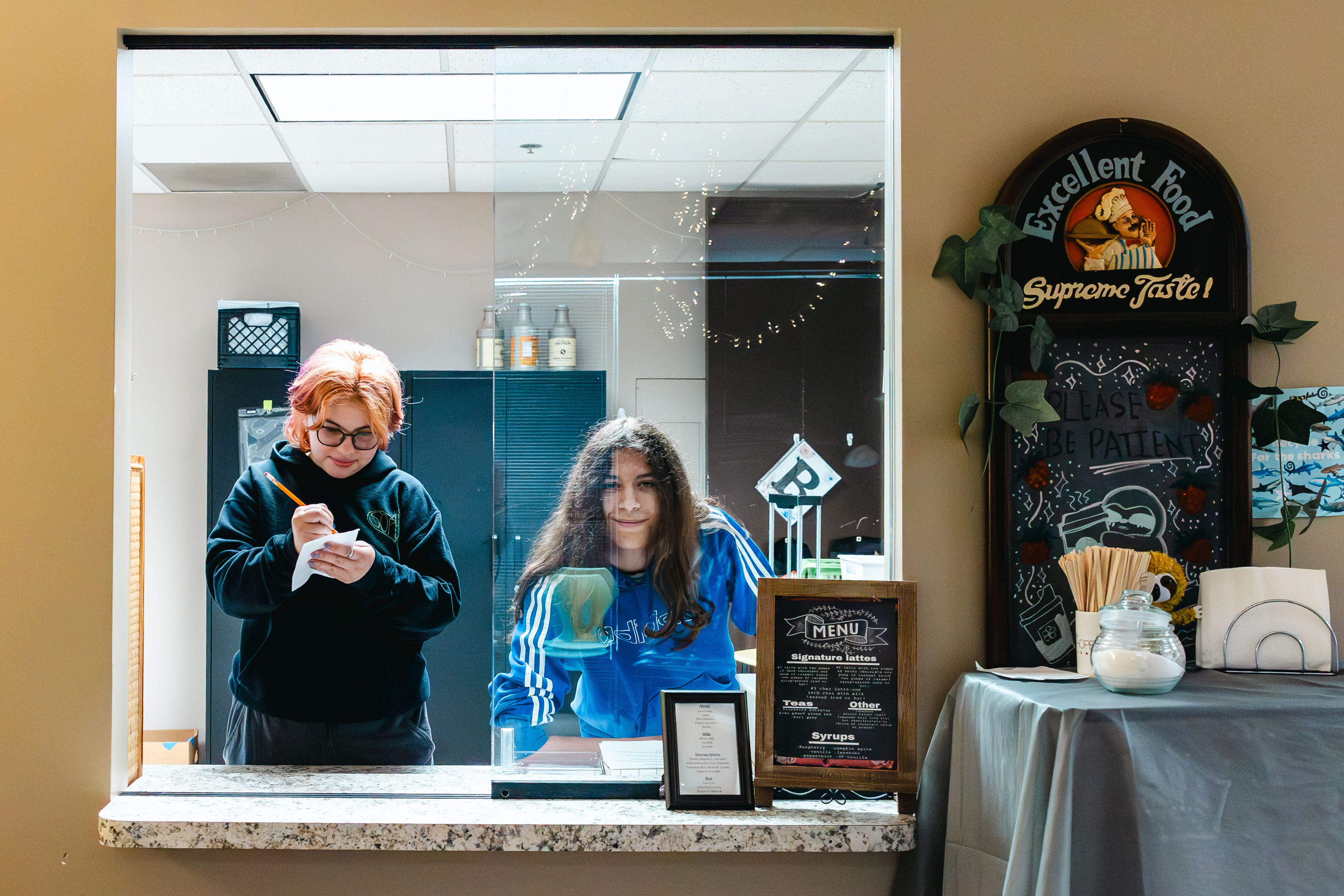 NewHope Academy students practice vocational skills while working behind a school cafe counter.