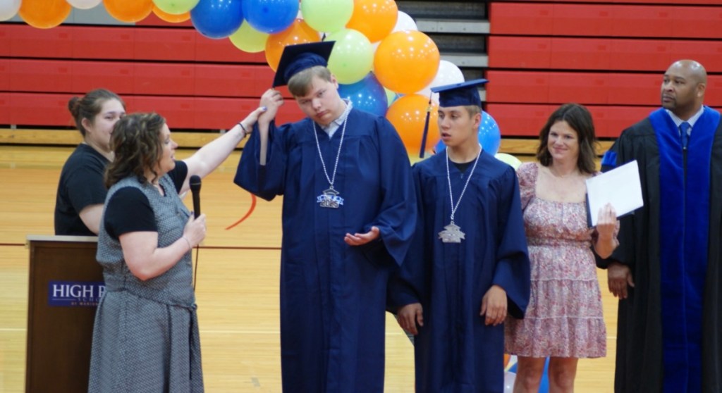 Students walking across stage at High Road School Marion County graduation