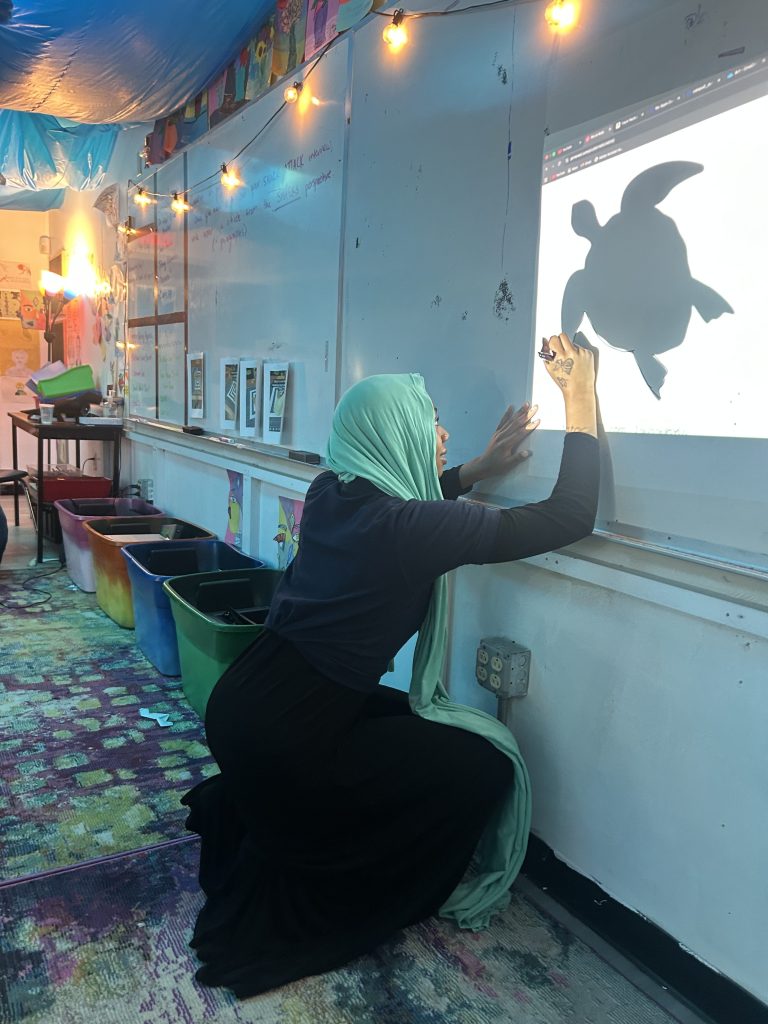 Excel Academy South member tracing turtle during Shark Week project