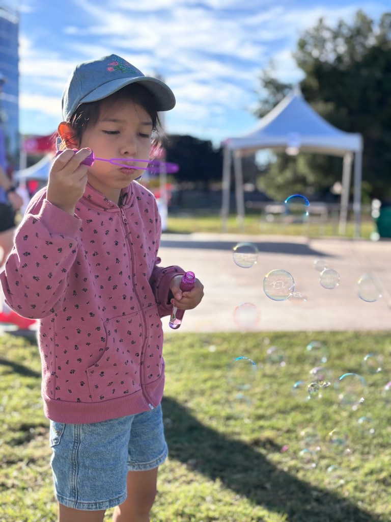 Sierra Schools of Arizona attendee blowing bubbles at YES Day Walk for Autism resource fair