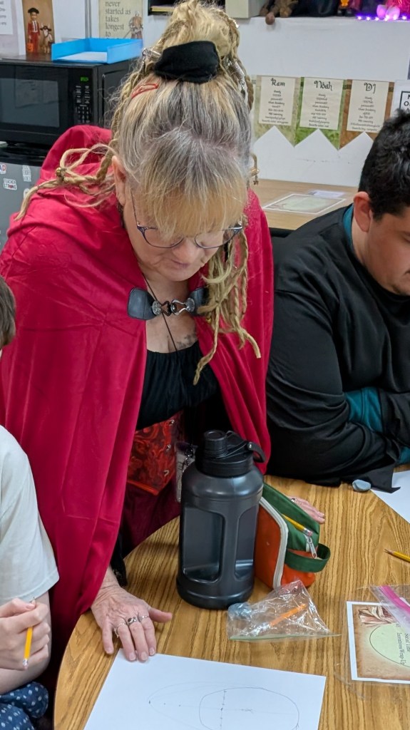 Air Force veteran teacher Suzy Cherry helping a student at Sierra School of Gateway during Halloween