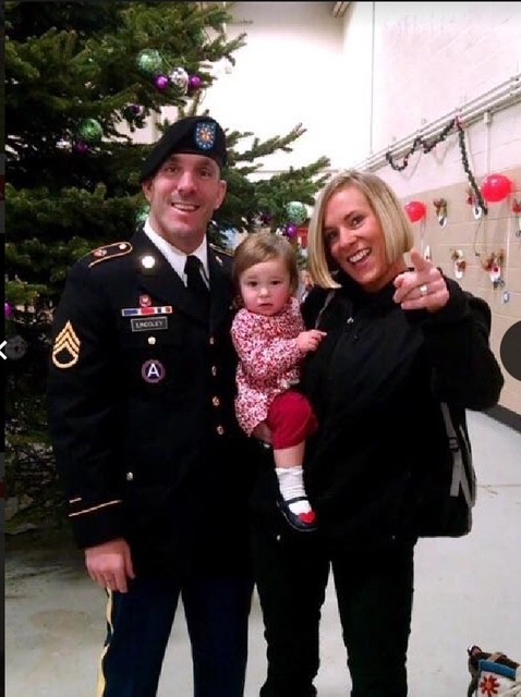 Veteran educator Vincent Lindsley in military uniform with barett standing with his Spouse and Child during the holidays