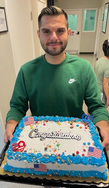Mr. Jesus celebrates at Sierra School of Gilbert citizenship event holding a congratulations cake after becoming a U.S. citizen.