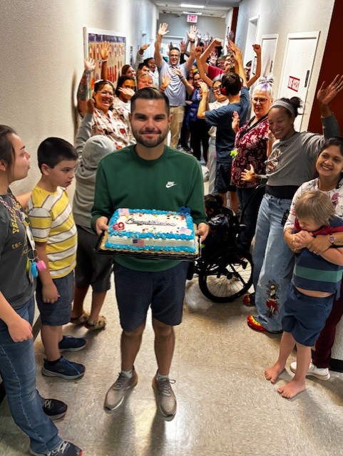 Sierra School of Gilbert staff and students celebrate Mr. Jesus during the citizenship celebration, cheering as he holds his cake in the hallway.