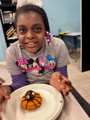 Student enjoying decorated donuts during therapy session.