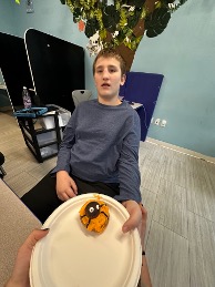 Student enjoying decorated donuts during therapy session.