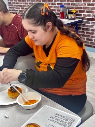 Students using fine motor skills to decorate donuts during therapy session.