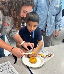 Therapists guiding students through step-by-step spooky snacks recipe.