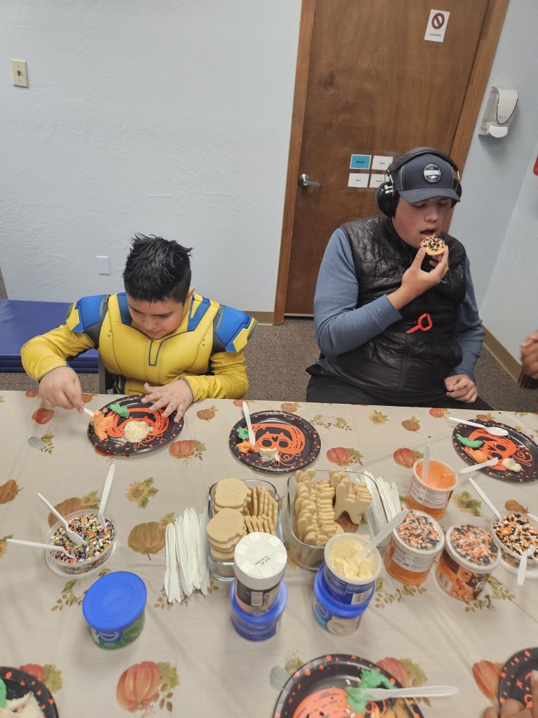 Students decorating cookies at Lattice Fall Festival 2025 with icing, sprinkles, and sensory play.