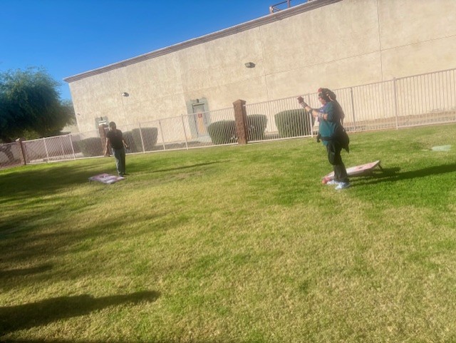 Los miembros del personal de Sierra Gilbert jugando juntos al cornhole durante la celebración escolar.