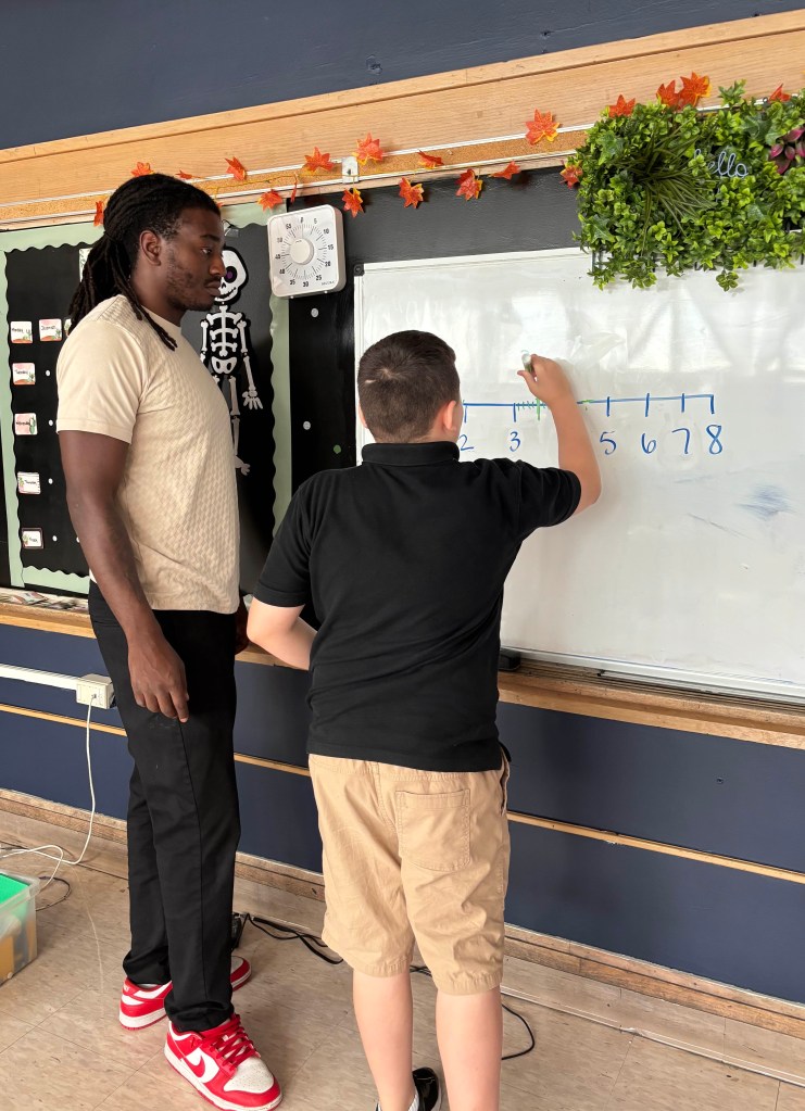 Aiden practicing number skills with support at High Road School
