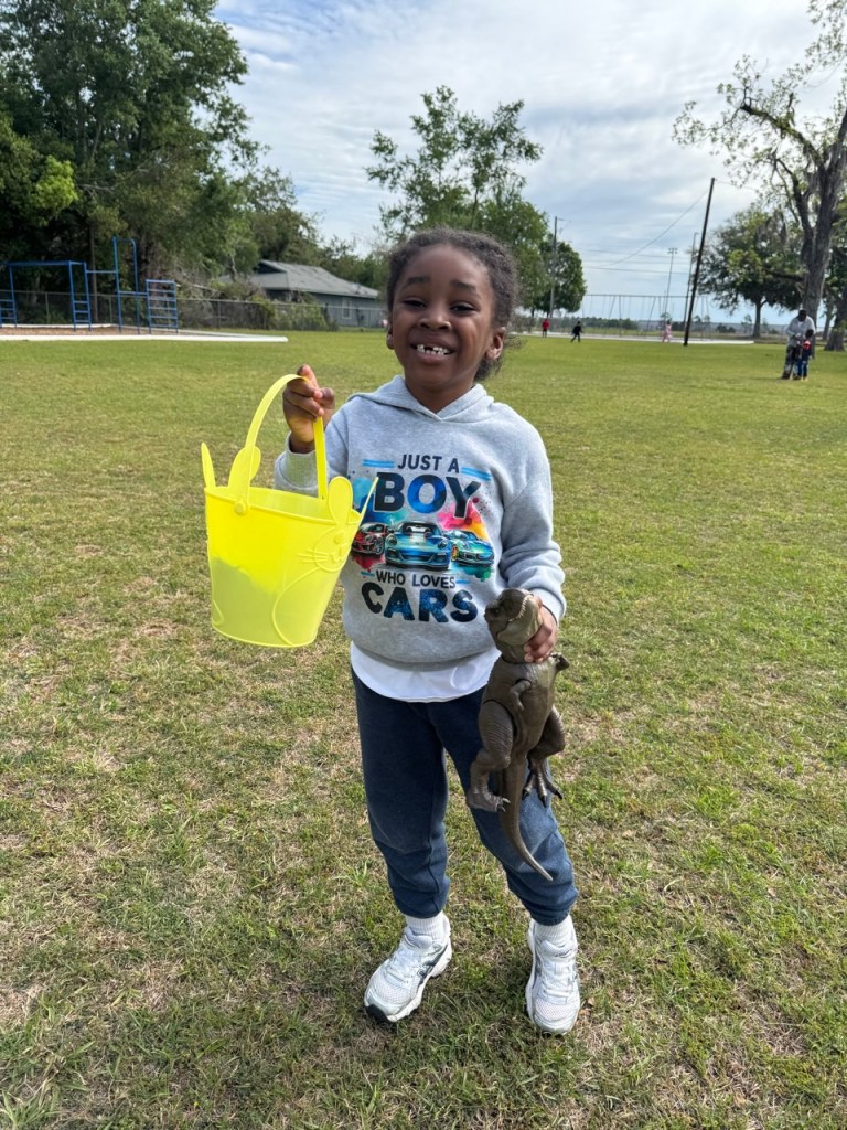 Student holding bucket and toy during school Easter egg hunt