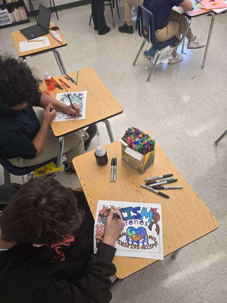 Alumnos pintando dibujos en sus pupitres en el aula