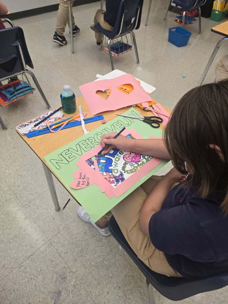 Estudiante trabajando en un proyecto artístico con papel y materiales