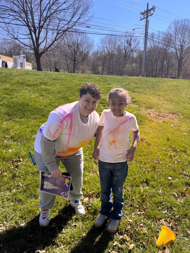 Staff and student smiling together at eye level during color walk