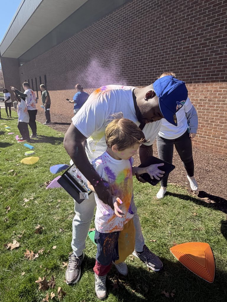 Student and staff participating in color walk with others active in background