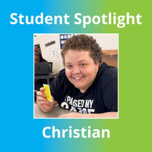 Christian smiling and holding a card during a classroom moment at Sierra School at Wylie