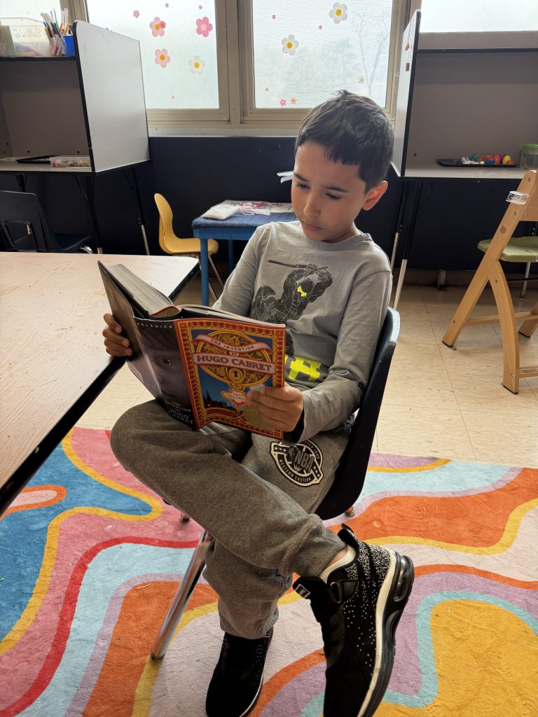 Un alumno lee *La invención de Hugo Cabret* durante el programa de lectura del colegio