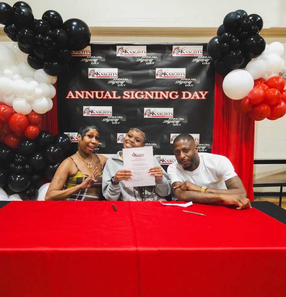 Un estudiante celebra el día de la firma de contratos con su familia en la Excel Middle Years Academy