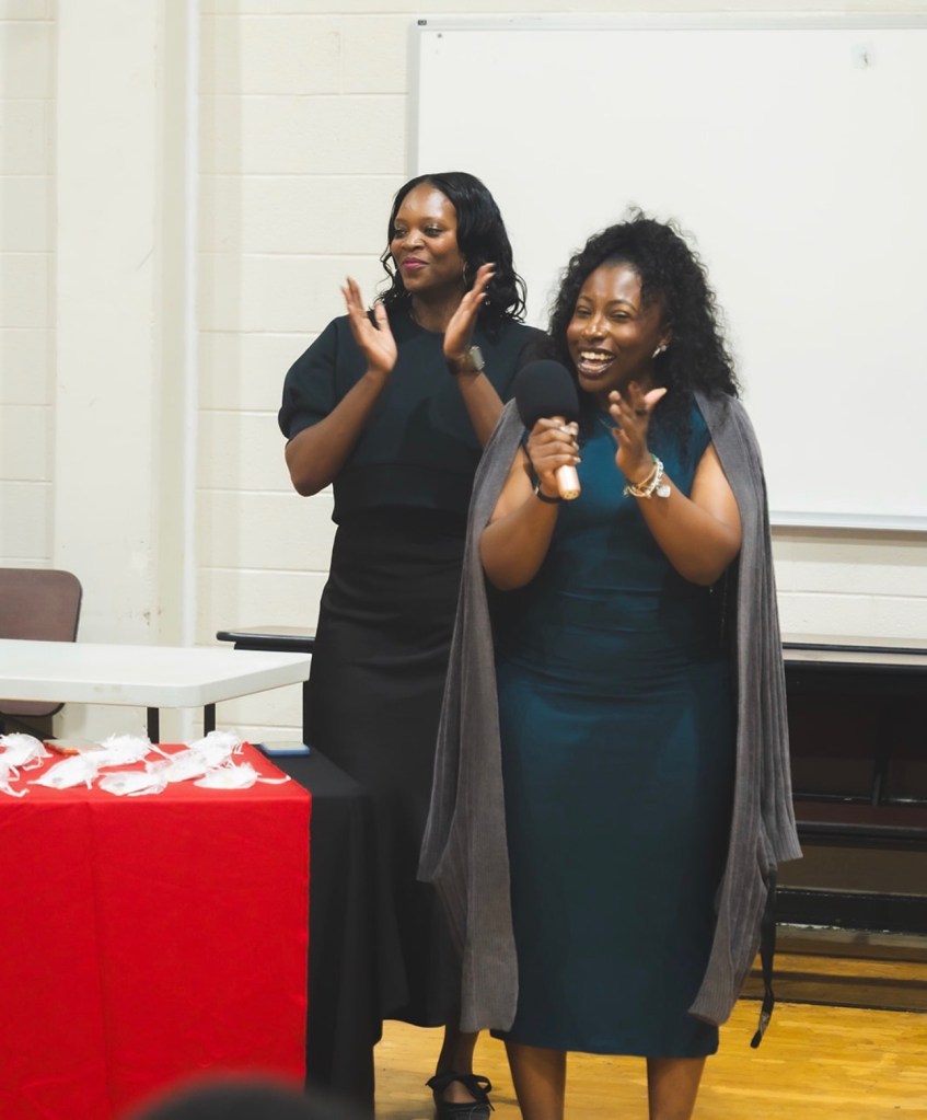El personal aplaude a los alumnos durante la celebración del «día de la firma» en la Excel Middle Years Academy