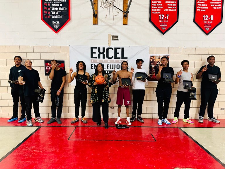Students stand in a line on the basketball court at Excel Academy of Englewood gym