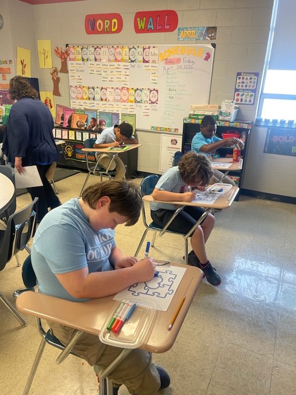 Students working on classroom projects during autism awareness activities at Delco Academy