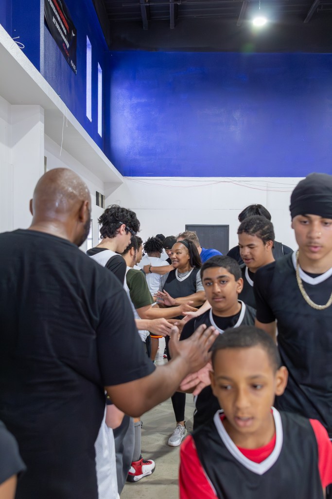 Students from opposing teams exchange high fives after a game during the Sierra Schools basketball tournament