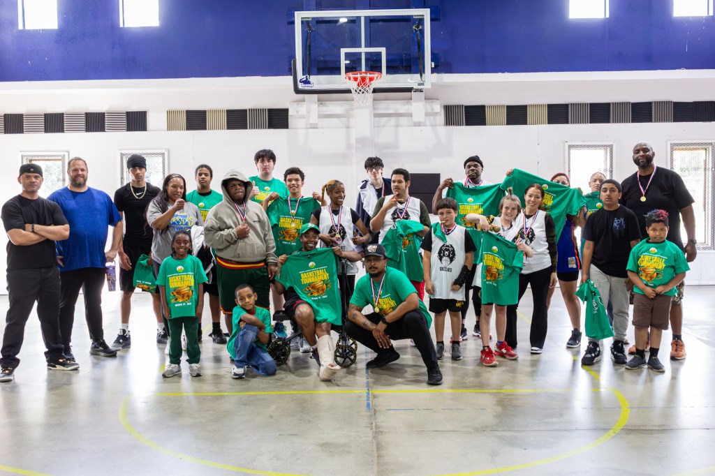 Students and staff from Sierra Schools stand together on the basketball court during the March Madness tournament