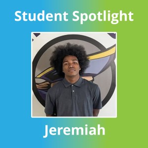 Student standing in front of Capital Academy logo during student spotlight feature