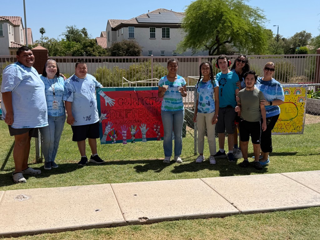 Estudiantes y personal con pancartas que celebran la diversidad en el desfile