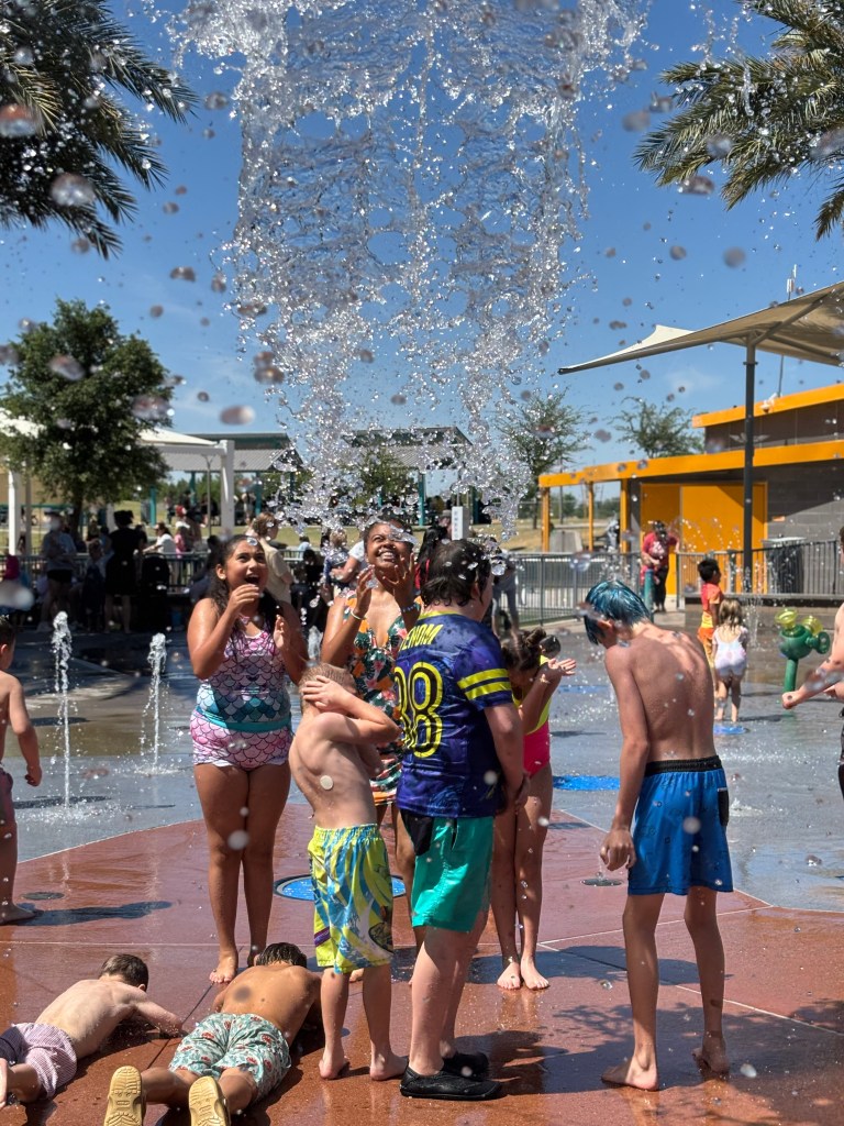 Students at Sierra School of Gilbert enjoying splash pad water jets during PBIS reward day
