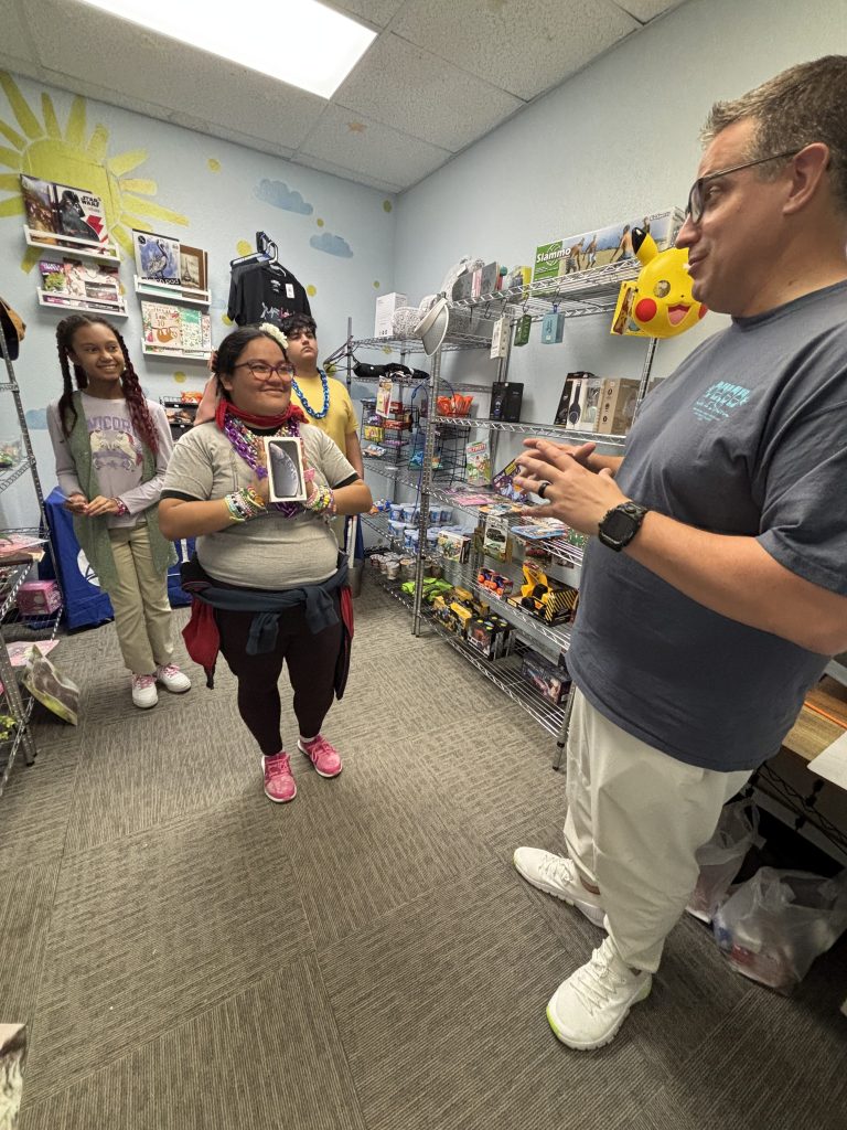 Yasmeen in the CASE Store with staff and students after earning an iPhone through the CASE Cash incentive program at Sierra School of Gilbert