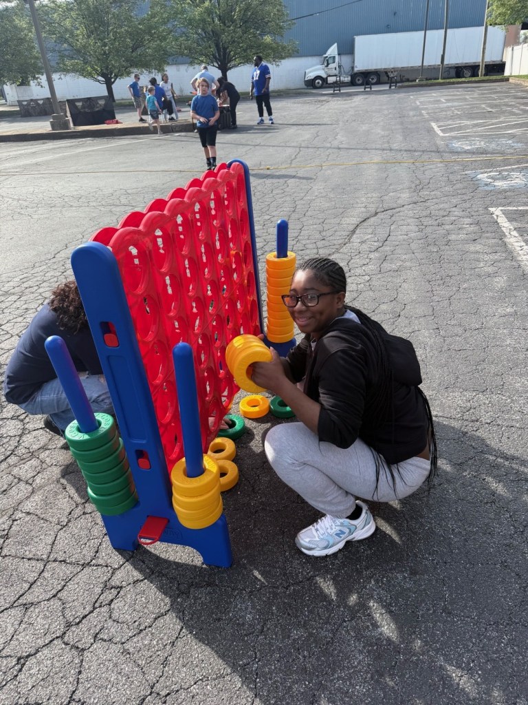 Students interacting with large Connect 4 game