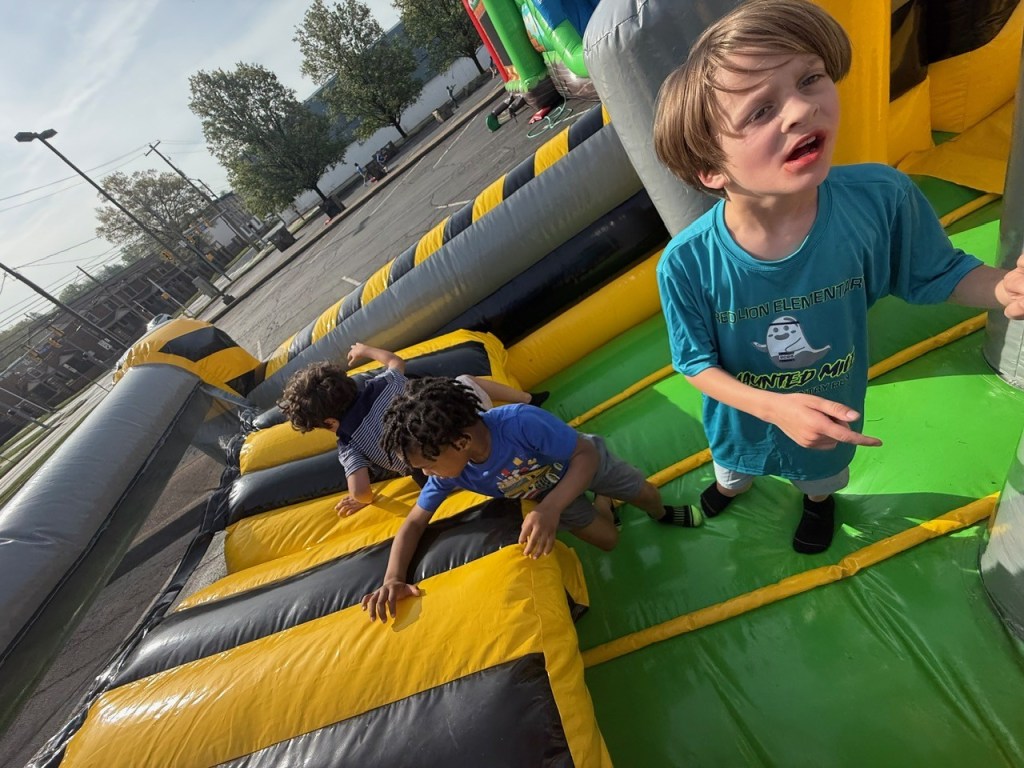 Students playing in bounce houses during school event