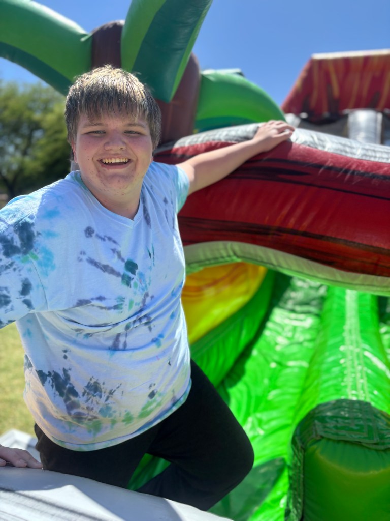 Un alumno sonríe en el castillo hinchable durante la fiesta del colegio