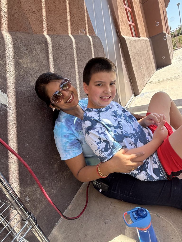 Un miembro del personal y un estudiante sonríen juntos con pompas de jabón a su alrededor