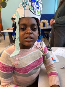 Teresa wearing a paper crown she created during a classroom activity