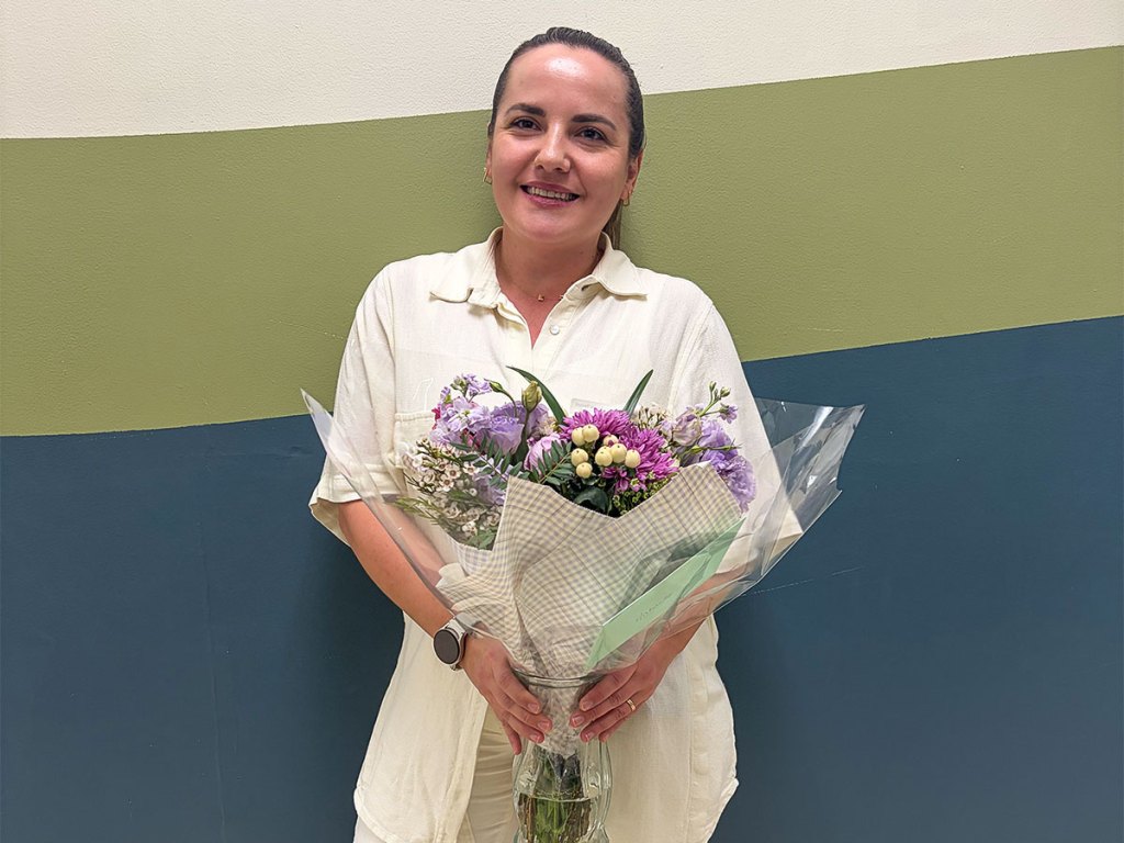 Antonela Qyra smiling while holding a bouquet of flowers after being named SESI’s 2026 Teacher of the Year.