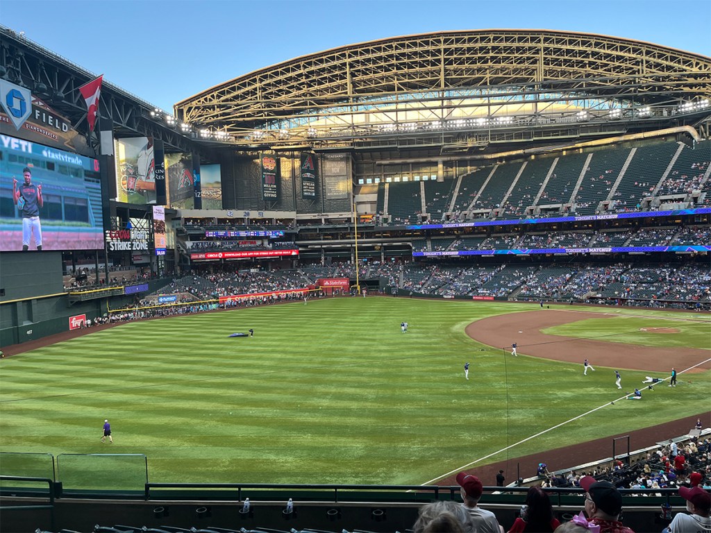 Arizona Diamondbacks players warm up on the field as fans arrive at Chase Field before the game.