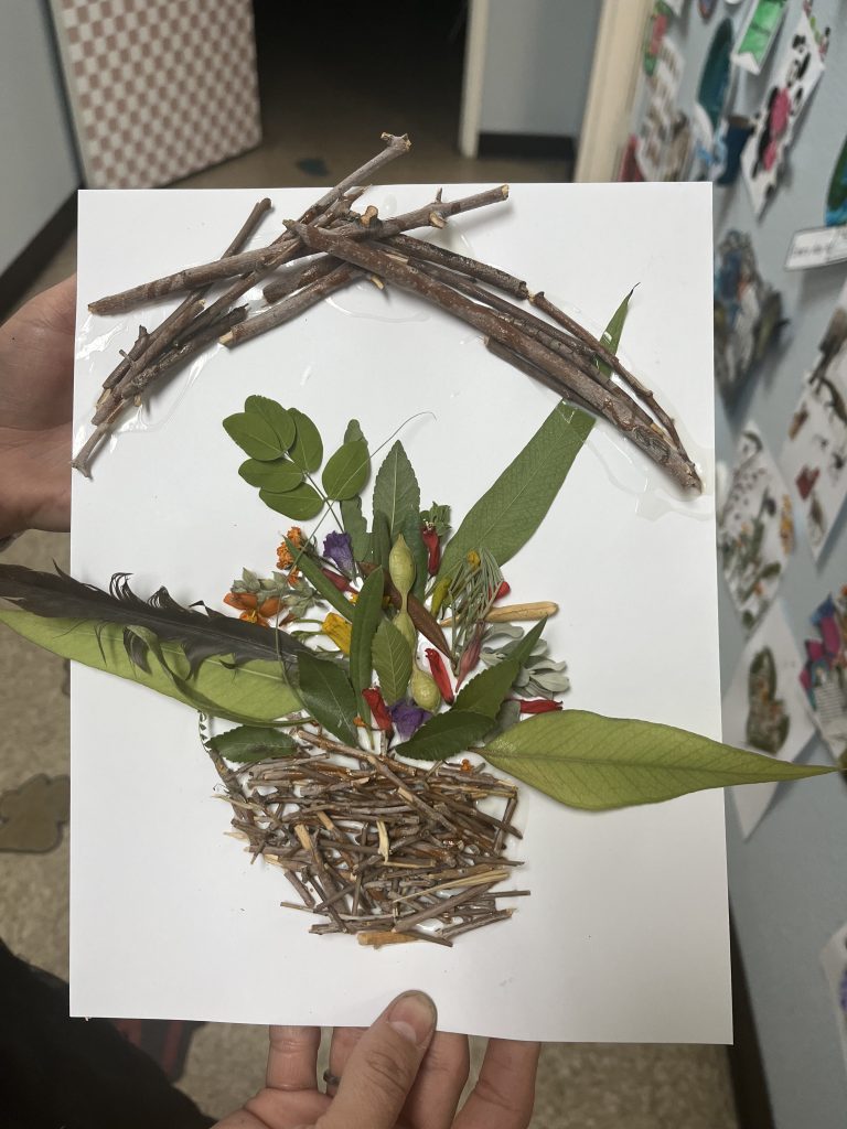 Handmade flower basket craft created with sticks, plants, and flowers as part of spring classroom activities.