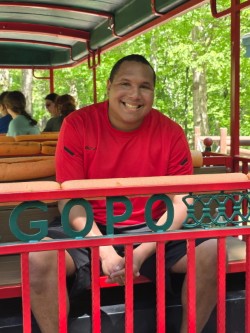 Vaughn smiling while riding the zoo train during a field trip with classmates and staff.