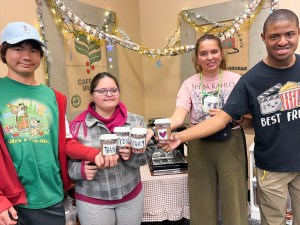 Los alumnos de la Sierra School de San Diego sostienen tazas de café que forman las palabras «Gracias, NFAR» mientras celebran el apoyo al programa de formación profesional «Coffee Corner».